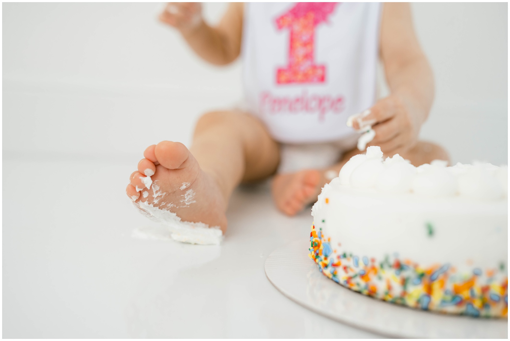 Details of a baby's foot covered in cake icing next to a cake after visiting birthday party venues in OKC