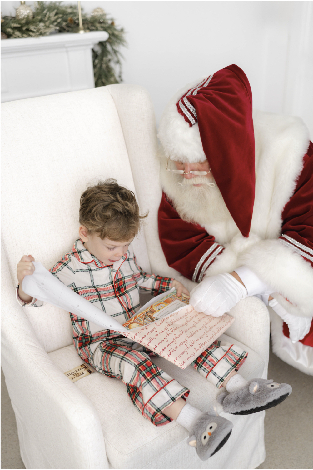 A young boy opens a present with Santa during holiday events in okc