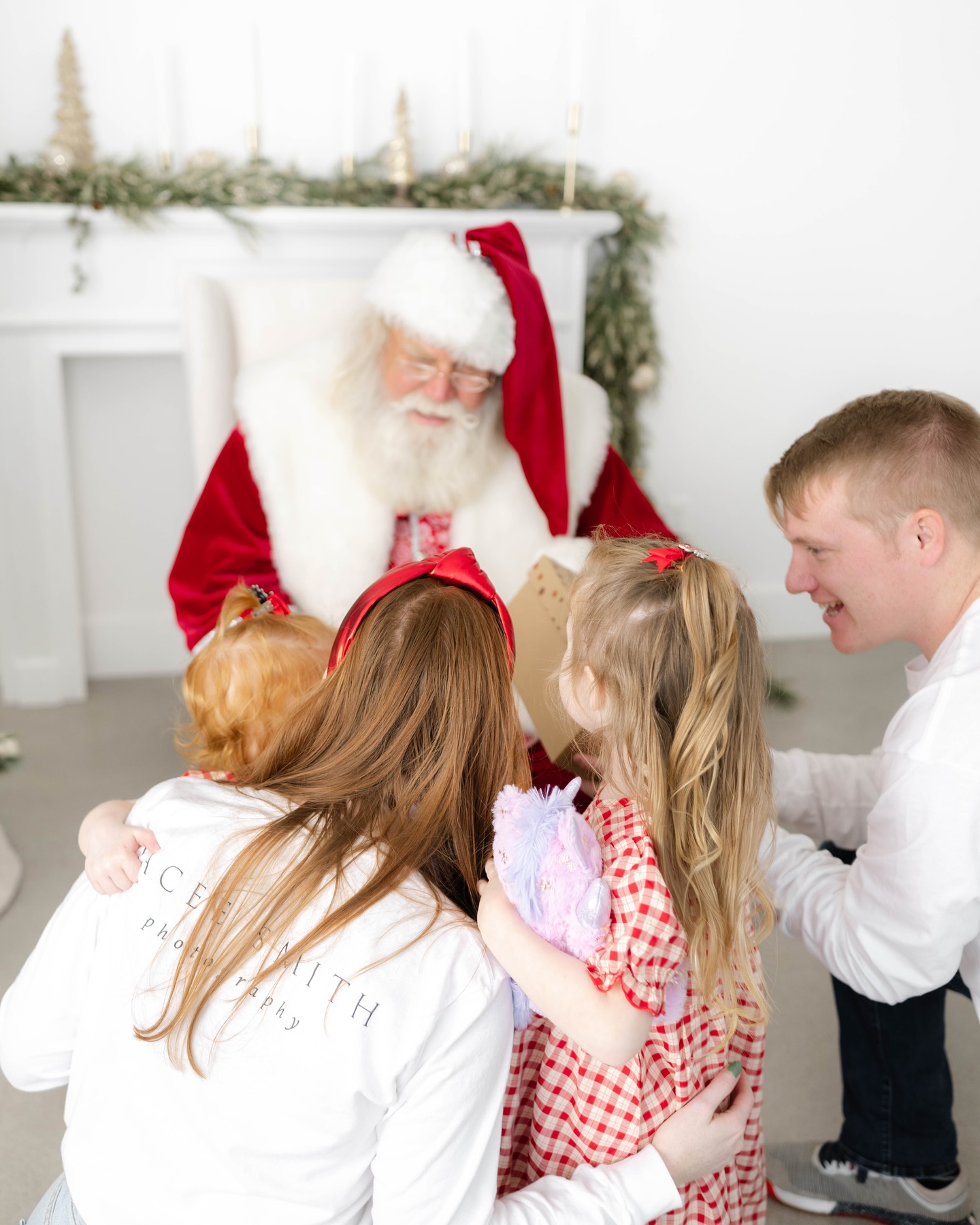 A family with two toddlers give letters to Santa in a studio during holiday events in okc