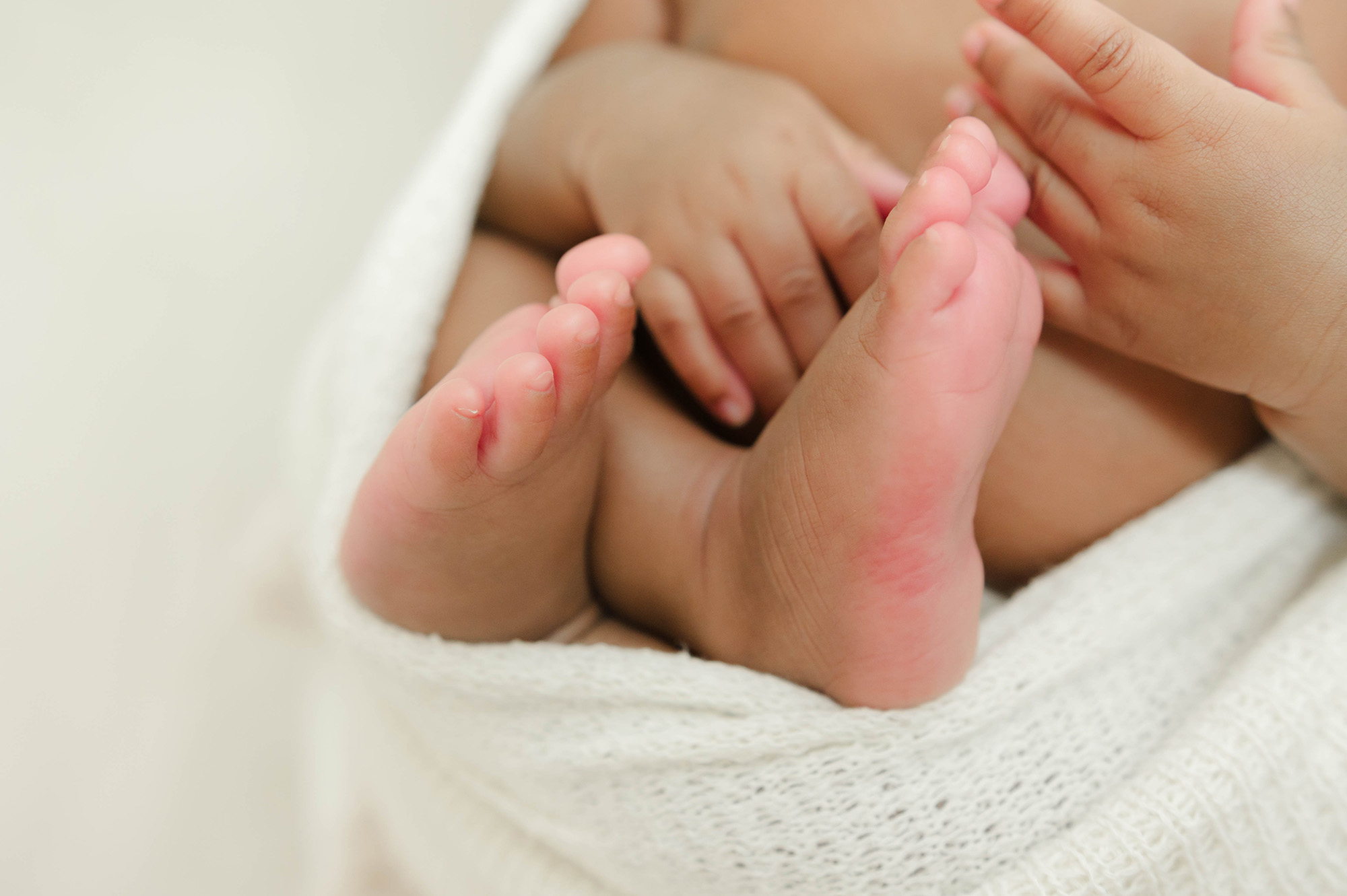 Details of a newborn's feet in a white swaddle