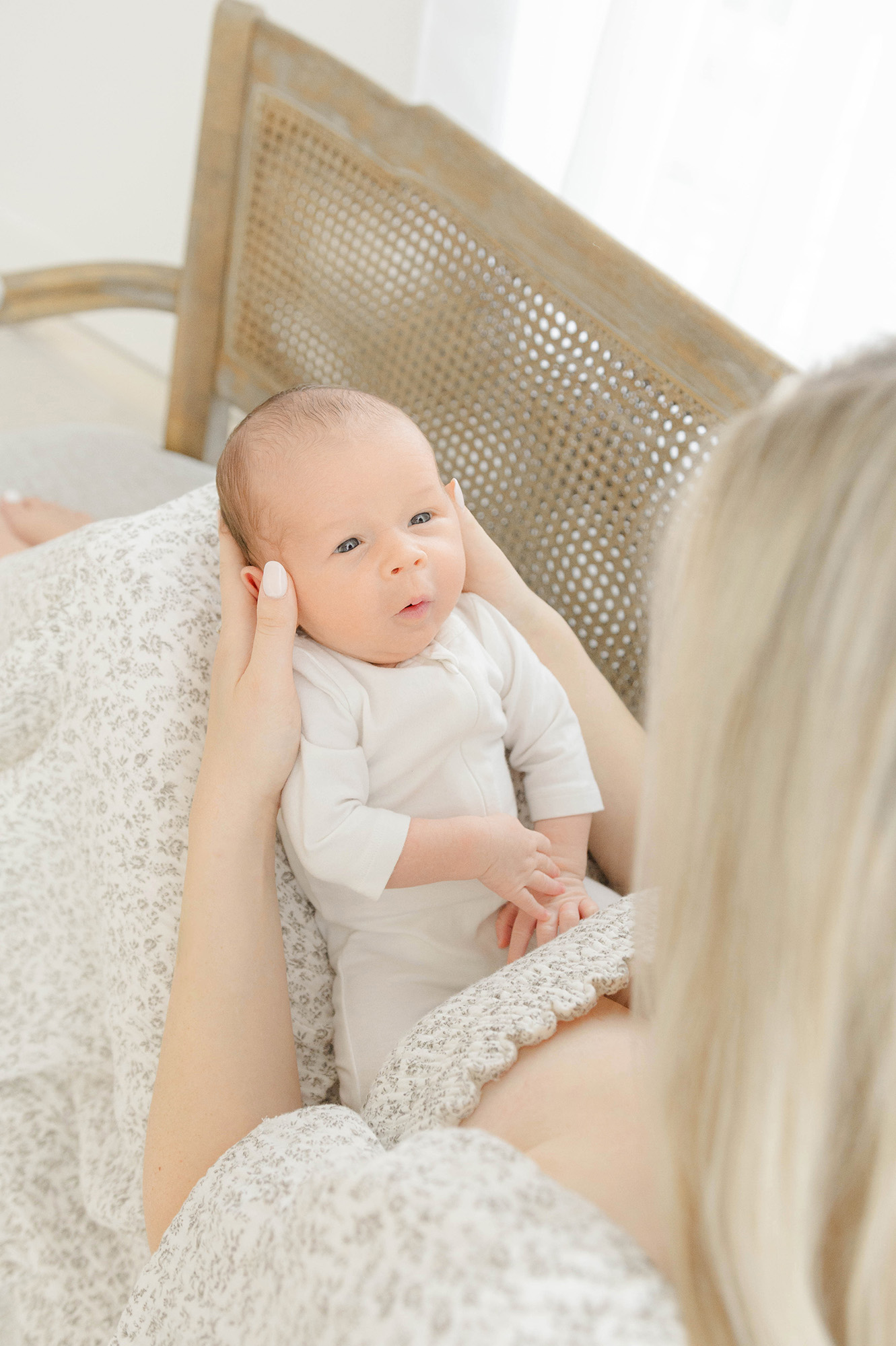 A newborn baby makes a silly face while looking up at mom from her lap after using willow birth services