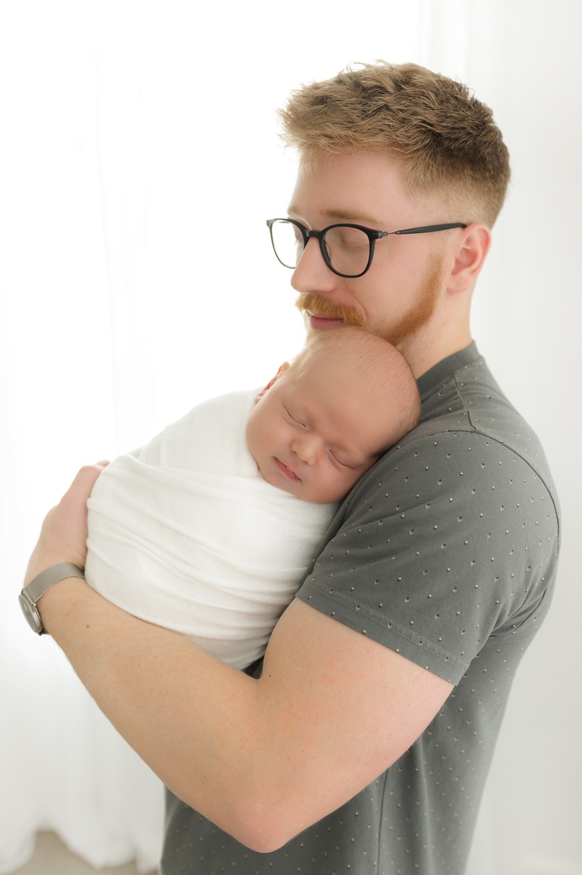 a father holding his baby who always wondered when is the best time to take newborn photos