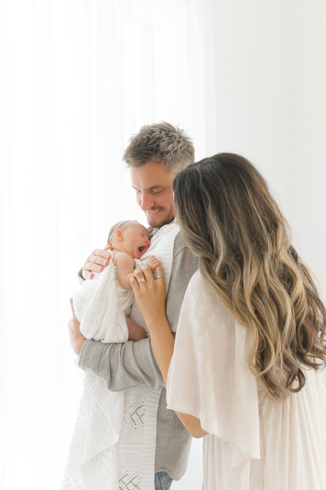 a mom and dad taking newborn birth photos with their newborn baby