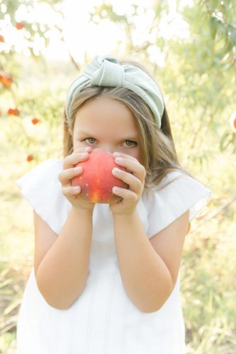 the peach tree farm photos of a girl holding a peach